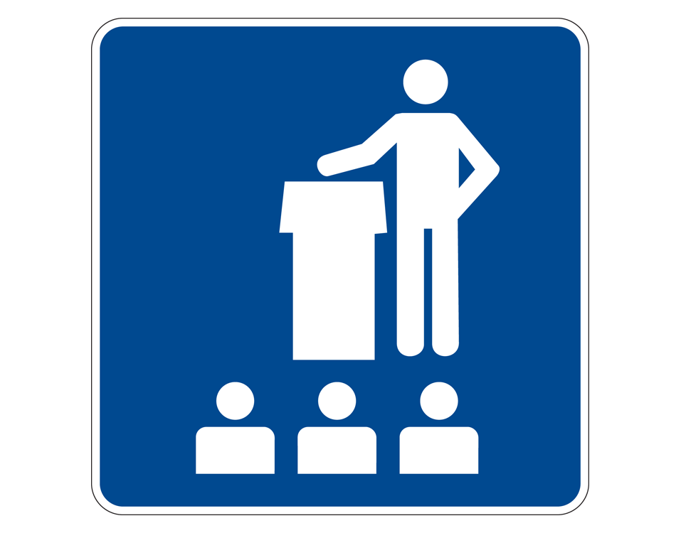 Person standing beside a lectern in front of 3 pupals 