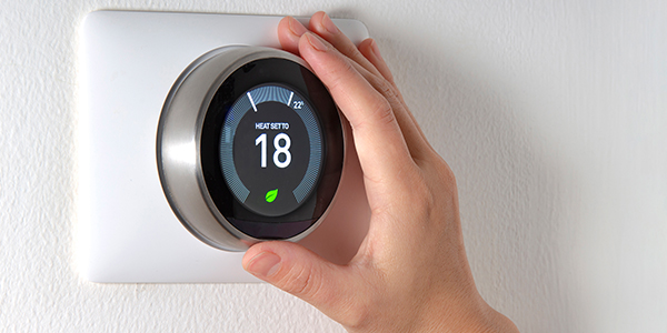 A hand turning a thermostat
