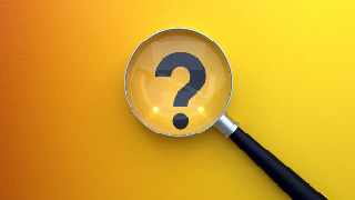 Question mark viewed within a magnifying glass