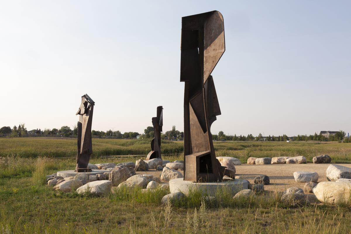 three metal sculptures in a park