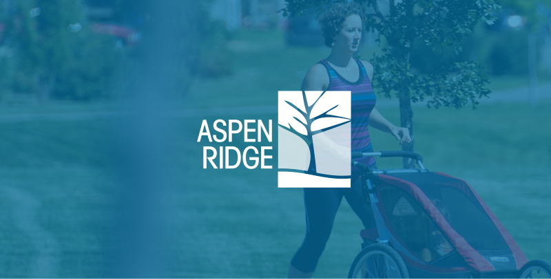 Aspen Ridge text on a blue overlay on top of a photo of a woman jogging with a stroller through a park