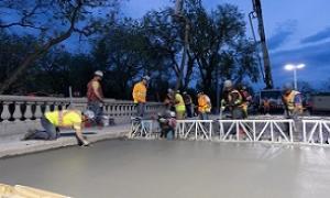 Crew smoothing concrete